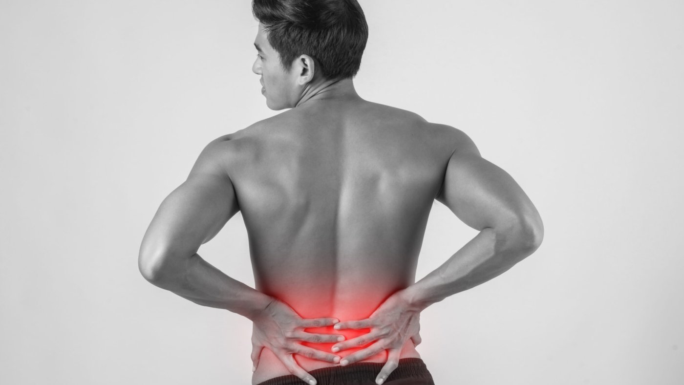 Close up of man rubbing his painful back isolated on white background.