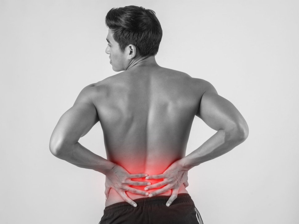 Close up of man rubbing his painful back isolated on white background.