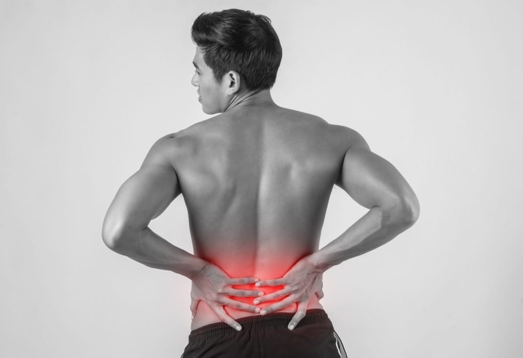 Close up of man rubbing his painful back isolated on white background.